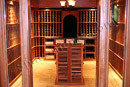 This custom wine cellar with a tasting table in a finished basement in Delaware County has a glass entryway.